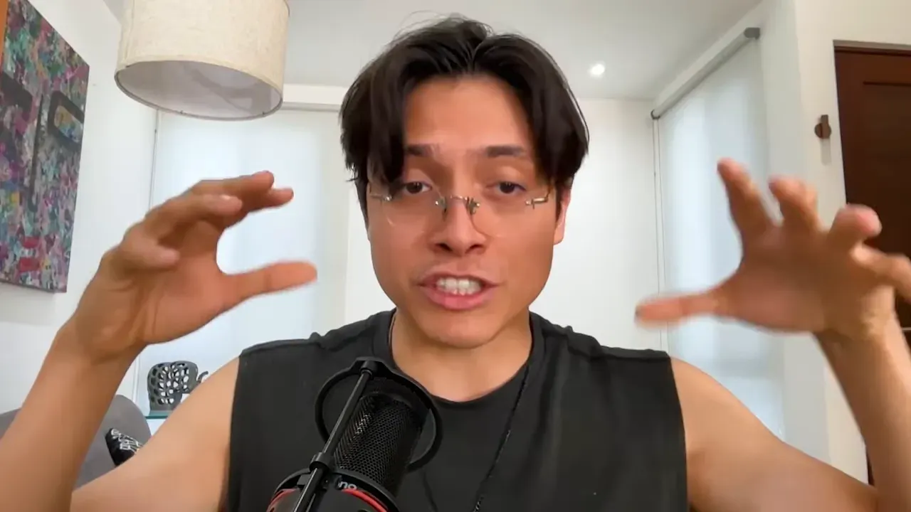 Interview subject using wide hand gestures while explaining strategy with microphone visible